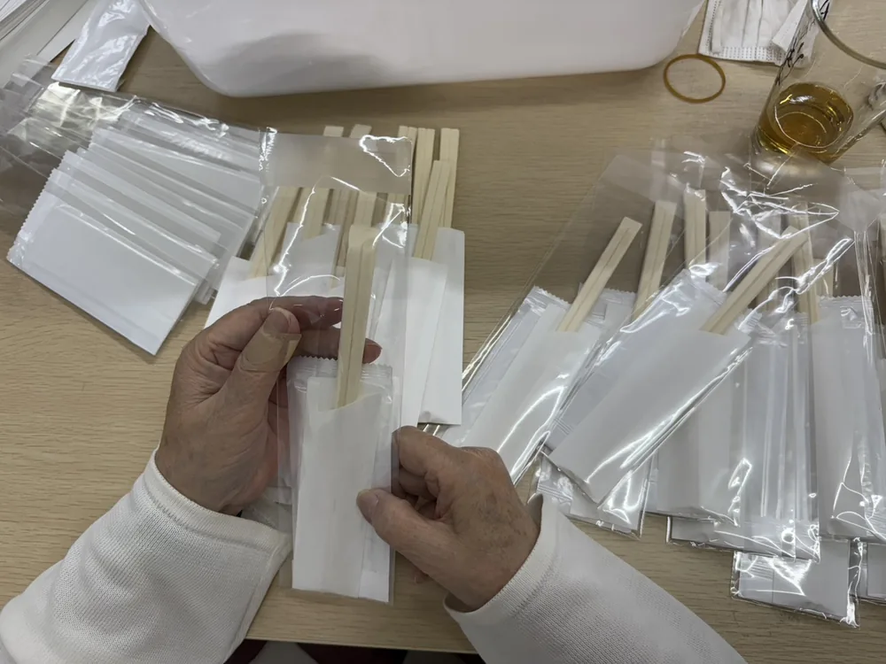 お箸を袋詰めする作業の手元